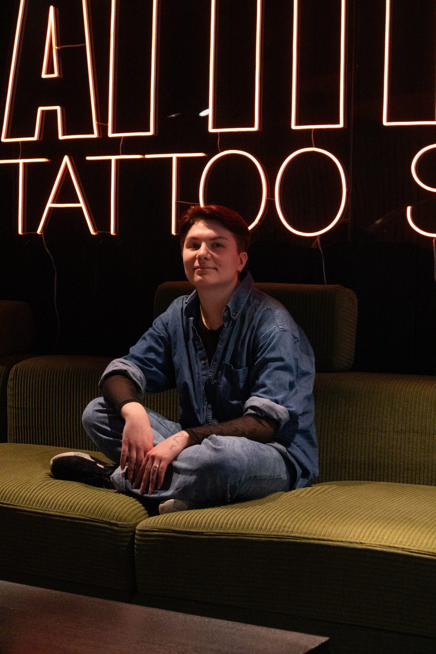ANJA SITTER I SOFAEN PÅ VENTEROMMET PÅ ATTITUDE TATTOO STUDIO