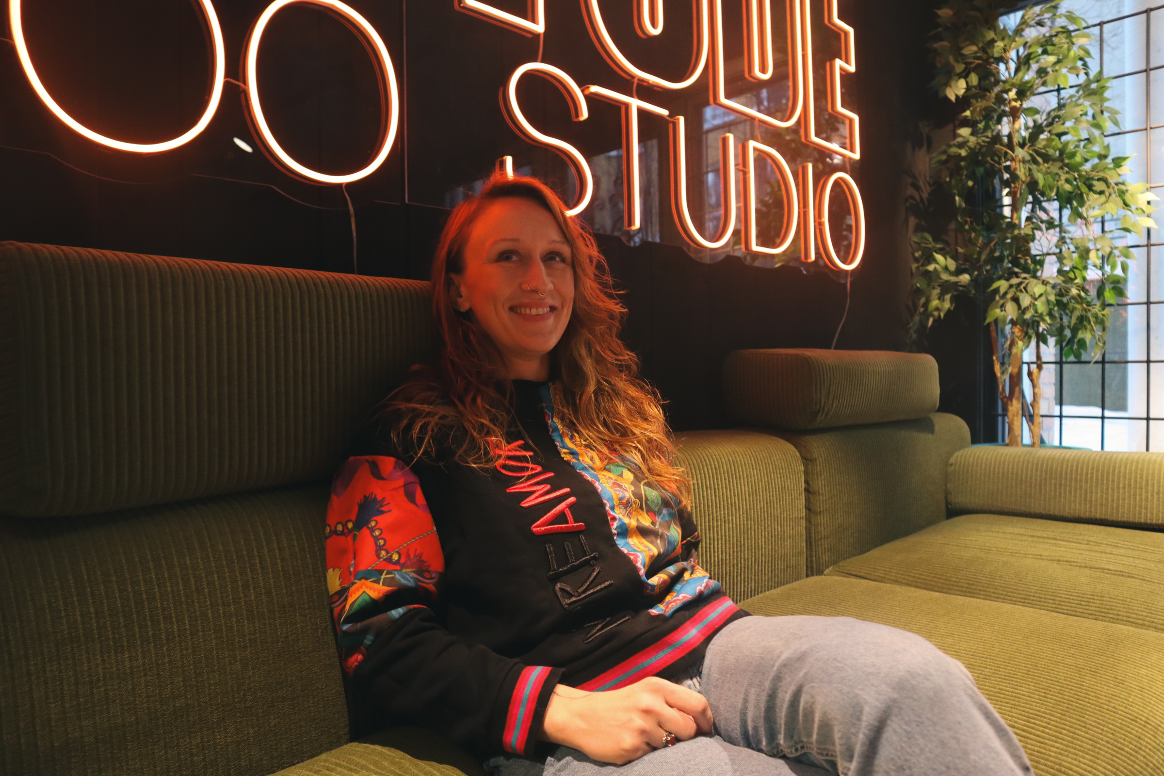 Kasia sitter i sofaen på ventrommet på Attitude tattoo studio. Portrettintervju