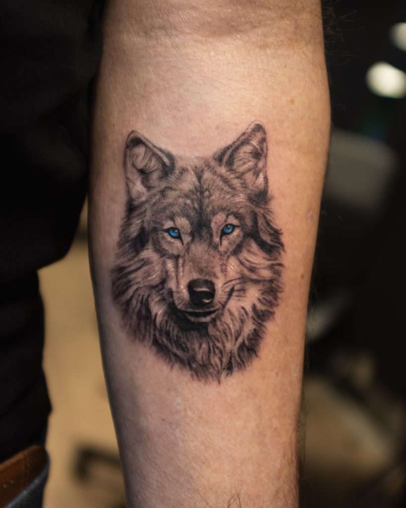 en ulv er tatovert på en arm